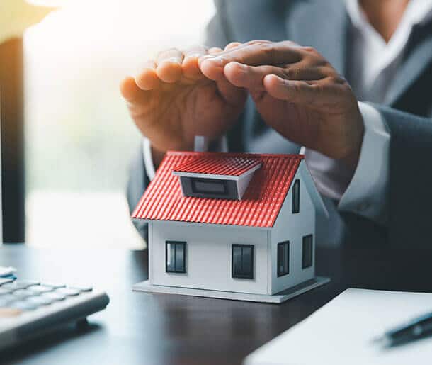 Hands protecting a house model